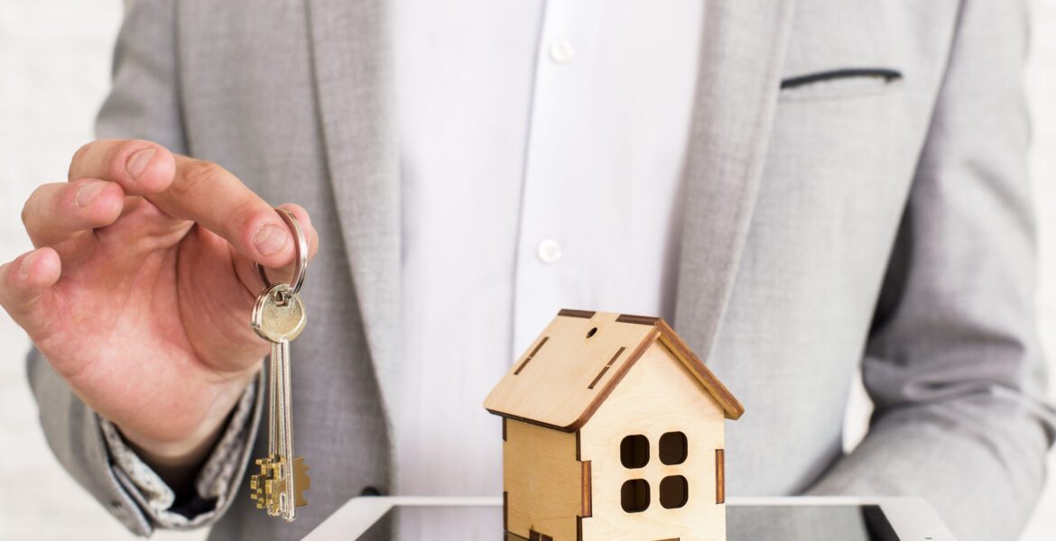 Persona entregando llaves de propiedad, símbolo de estafas inmobiliarias